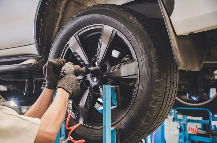 Mechanic changing a car tire in an auto shop